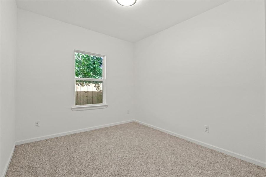 Carpeted spare room featuring baseboards