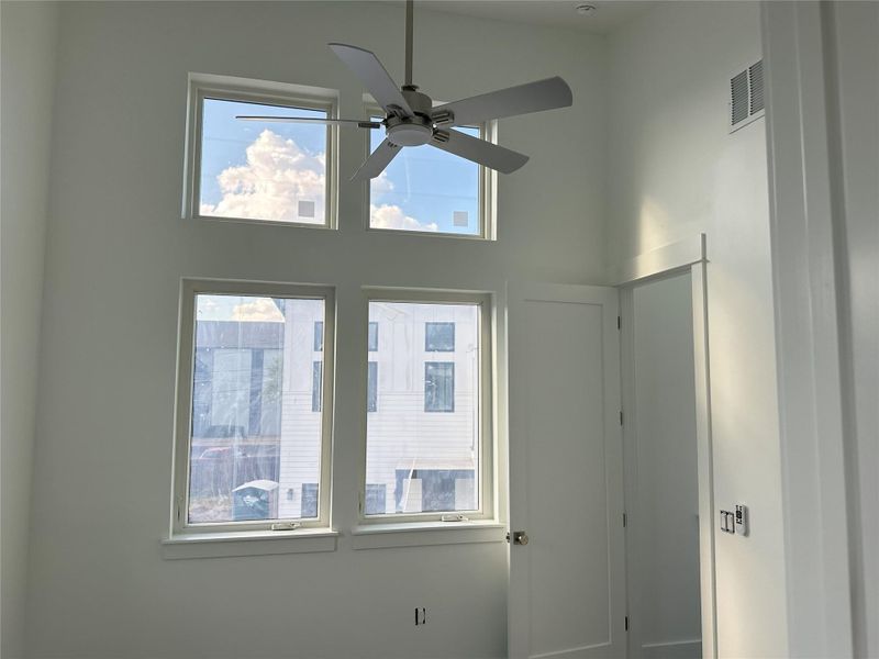 Secondary Bedroom with high vaulted ceilings, front window wall