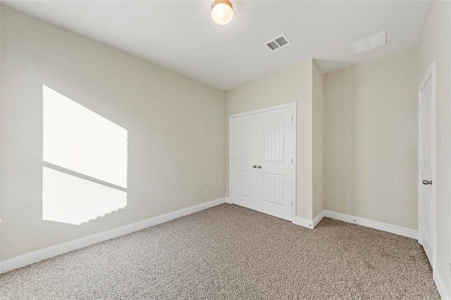 Unfurnished bedroom with carpet flooring and a closet