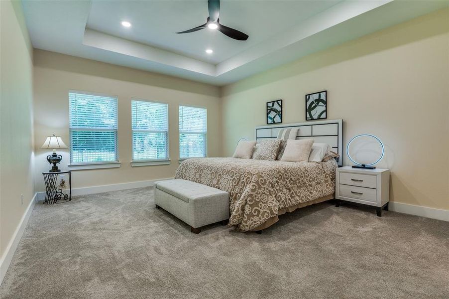 Primary suite with tray ceiling, king bedroom set with nightstands and storage bench. Primary suite with tray ceiling, king bedroom set with nightstands and storage bench.