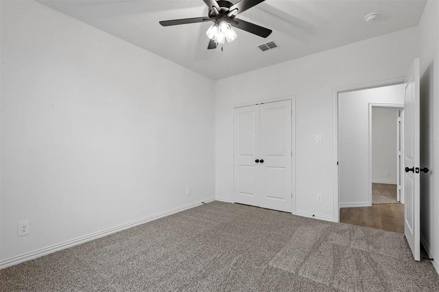 Unfurnished bedroom with carpet floors, ceiling fan, and a closet