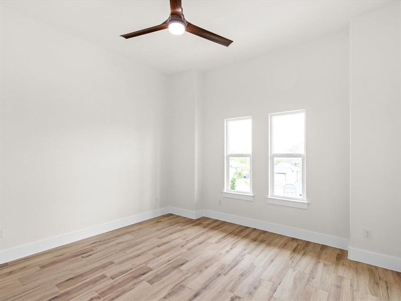 Empty room featuring light wood-style flooring and ceiling fan
