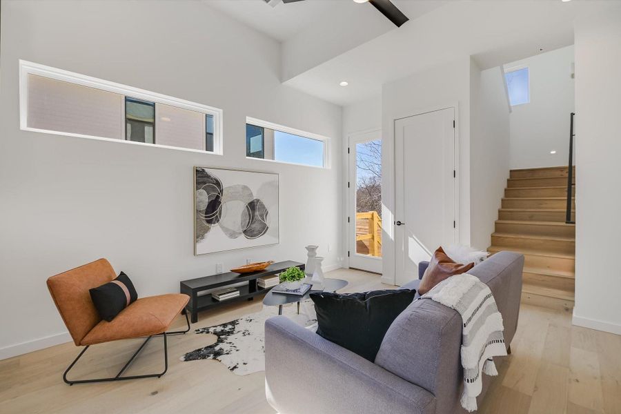 Living room with light hardwood / wood-style flooring and ceiling fan