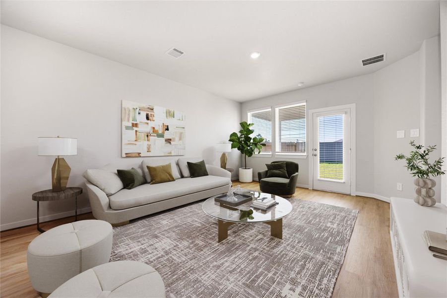 This bright and spacious living area features an open layout with large windows that fill the space with natural light. Elegant flooring and soft neutral tones create a warm, modern feel, while direct access to the backyard enhances indoor-outdoor living.