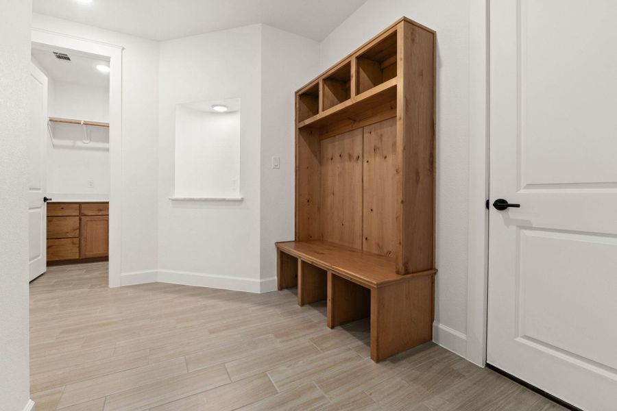 Mudroom featuring light wood finished floors and baseboards