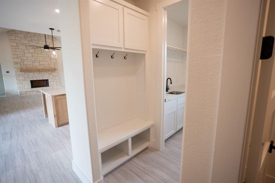 Mudroom featuring a stone fireplace, light wood-style flooring, a ceiling fan, and recessed lighting Mudroom featuring a stone fireplace, light wood-style flooring, a ceiling fan, and recessed lighting