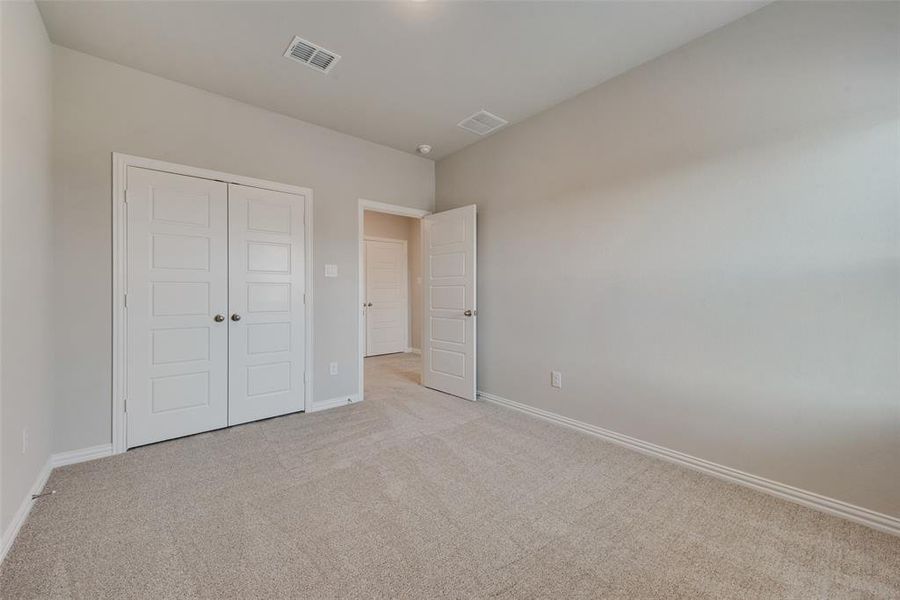 Unfurnished bedroom featuring light colored carpet and a closet