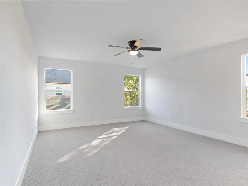 Carpeted spare room with ceiling fan