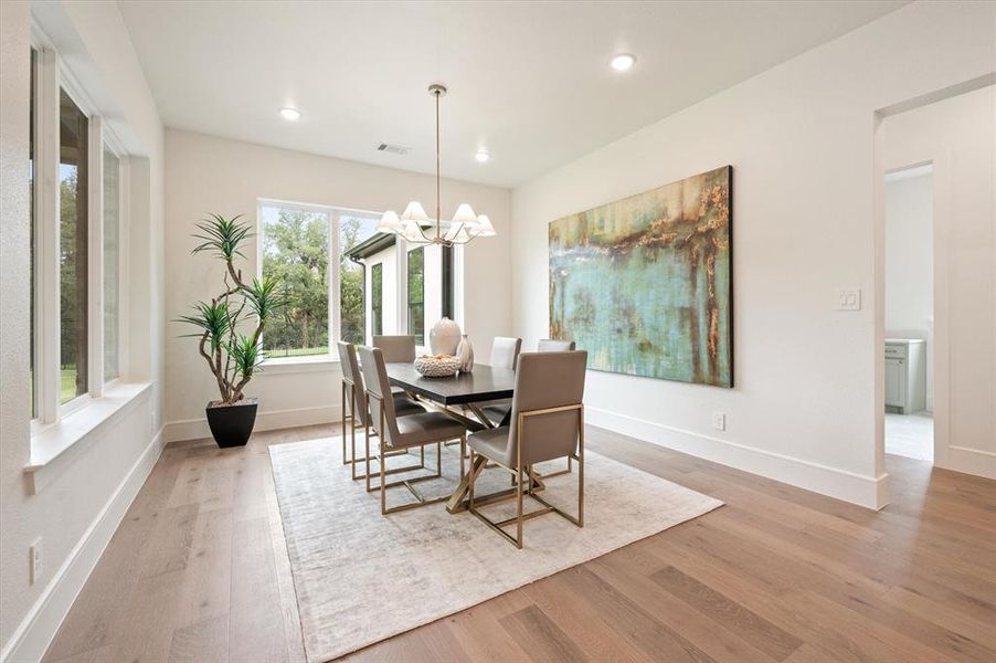 Dining room with a notable chandelier and light hardwood / wood-style flooring