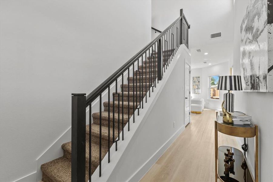 Stairway featuring wood finished floors, a high ceiling, and recessed lighting Stairway featuring wood finished floors, a high ceiling, and recessed lighting