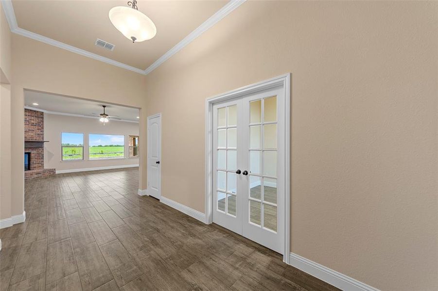 Corridor featuring crown molding, french doors, baseboards, and dark wood-type flooring