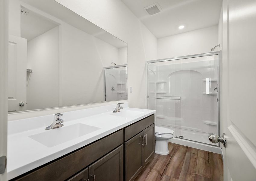 The spacious master bathroom features a glass enclosed shower.