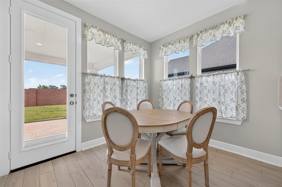 Cozy breakfast nook surrounded by corner windows offers natural light and views of the backyard. The space is perfect for casual dining with direct access to the covered patio.
