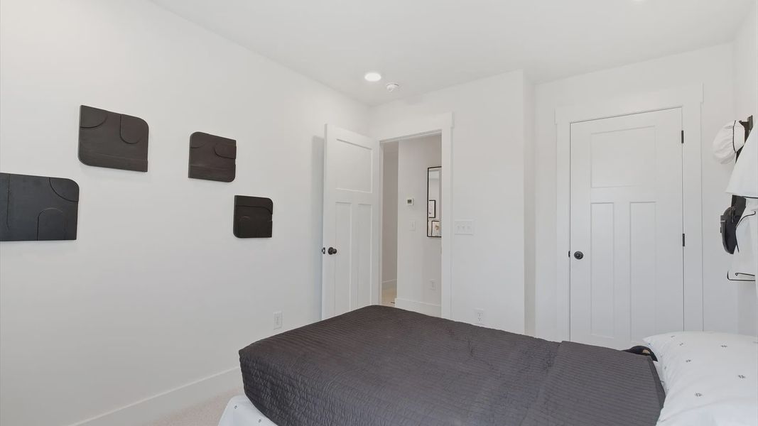 Superior comfort in a secondary bedroom with plush carpet and an oversized walk-in closet at the Churchill Design