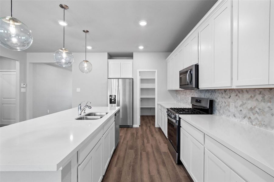 Welcome to the heart of the home, a modern, highly functional kitchen that perfectly balances style and utility. Quartz countertops, complemented by a stylish backsplash, shaker-style cabinets provide ample storage, and the Whirlpool stainless steel appliances are all features of this beautiful kitchen!