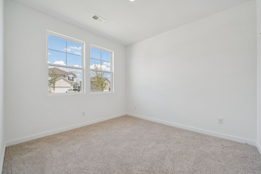 A room with a window and a carpet.