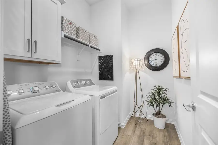 Laundry room featuring light wood-type flooring, cabinet space, and independent washer and dryer Laundry room featuring light wood-type flooring, cabinet space, and independent washer and dryer