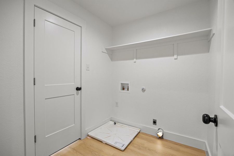 Laundry area featuring washer hookup, electric dryer hookup, light wood-style floors, and hookup for a gas dryer Laundry area featuring washer hookup, electric dryer hookup, light wood-style floors, and hookup for a gas dryer