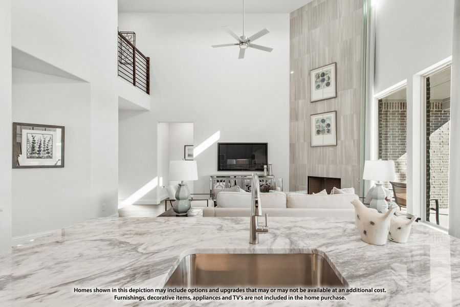 Open-concept living area with two-story ceiling, marble kitchen island, and fireplace accent wall Open-concept living area with two-story ceiling, marble kitchen island, and fireplace accent wall