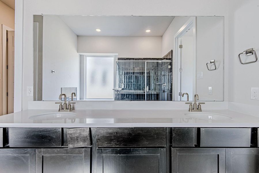 Expansive dual-sink vanity with quartz countertops and modern lighting. Expansive dual-sink vanity with quartz countertops and modern lighting.