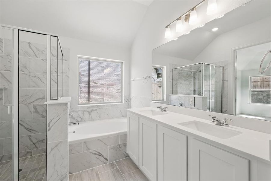 Bathroom with a stall shower, vaulted ceiling, a sink, and a bath