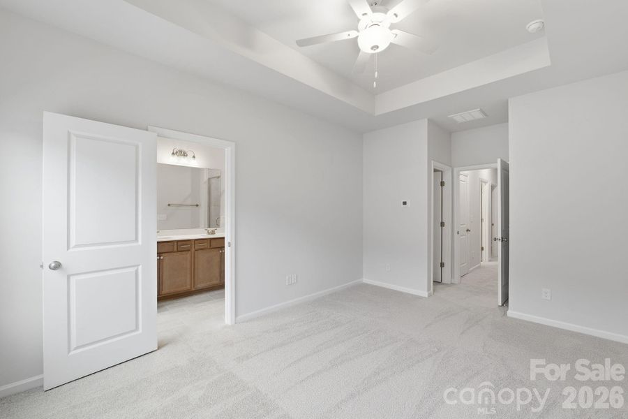 Primary Bedroom with 10' Tray Ceiling Primary Bedroom with 10' Tray Ceiling