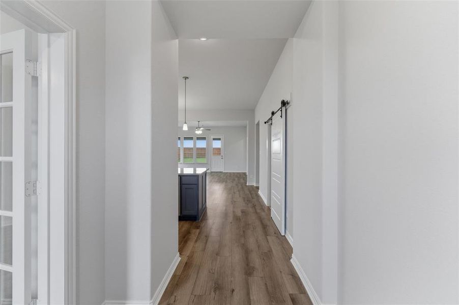 Long hallway with wood-finish flooring extending into the background