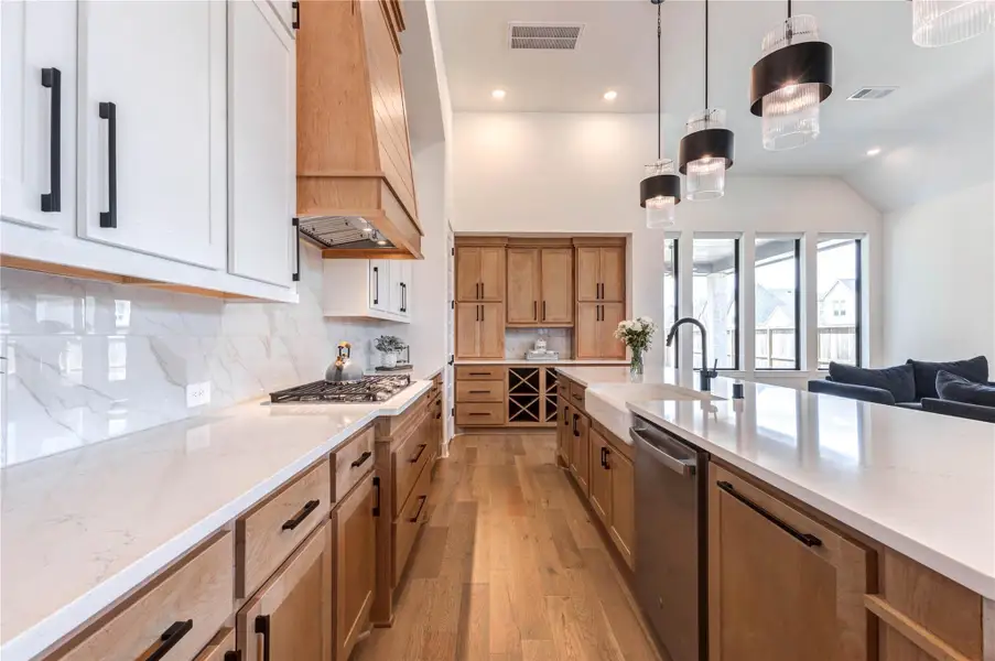 This open-concept living space features a modern kitchen with an island and pendant lighting, adjacent to a cozy living area with a sleek fireplace and large windows. The room is airy and bright, with hardwood floors and high ceilings. This open-concept living space features a modern kitchen with an island and pendant lighting, adjacent to a cozy living area with a sleek fireplace and large windows. The room is airy and bright, with hardwood floors and high ceilings.