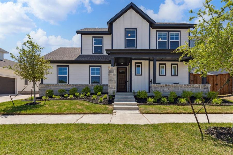 View of front facade with fence, a shingled roof, a front lawn, board and batten siding, and a porch View of front facade with fence, a shingled roof, a front lawn, board and batten siding, and a porch