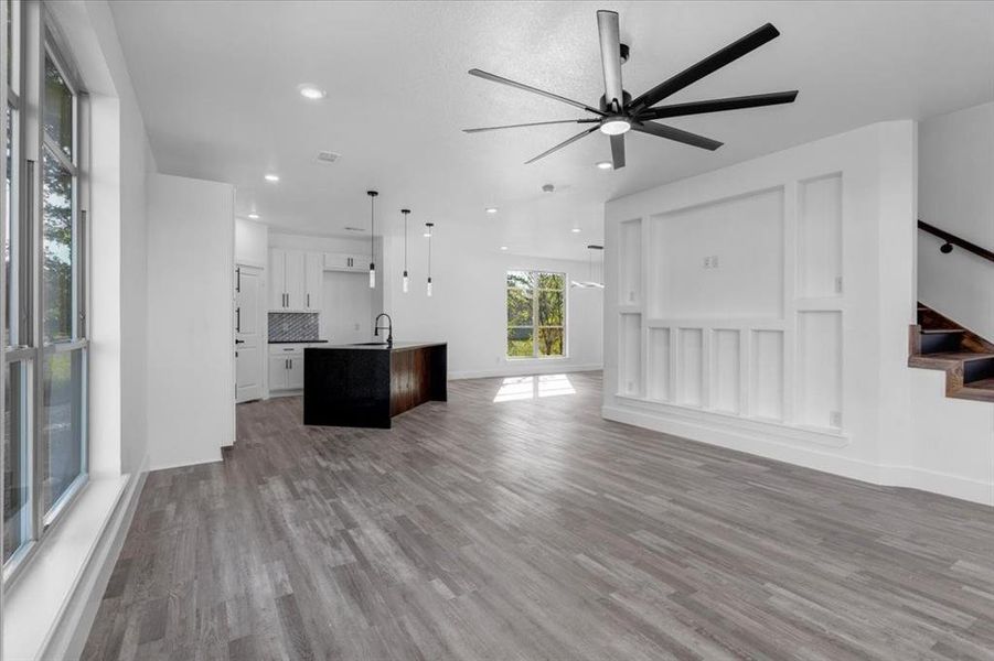 Unfurnished living room with hardwood / wood-style flooring, ceiling fan, and sink