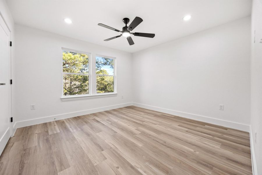 Spare room featuring light wood finished floors, ceiling fan, and recessed lighting