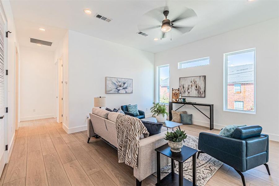 Living area featuring plenty of natural light, recessed lighting, light wood finished floors, and a ceiling fan Living area featuring plenty of natural light, recessed lighting, light wood finished floors, and a ceiling fan