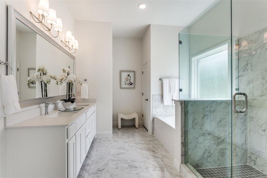 Bathroom featuring vanity, plus walk in shower, and a chandelier