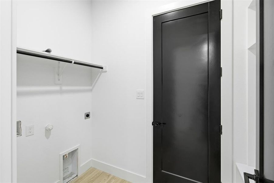 Laundry area featuring light wood-style floors, hookup for an electric dryer, and gas dryer hookup