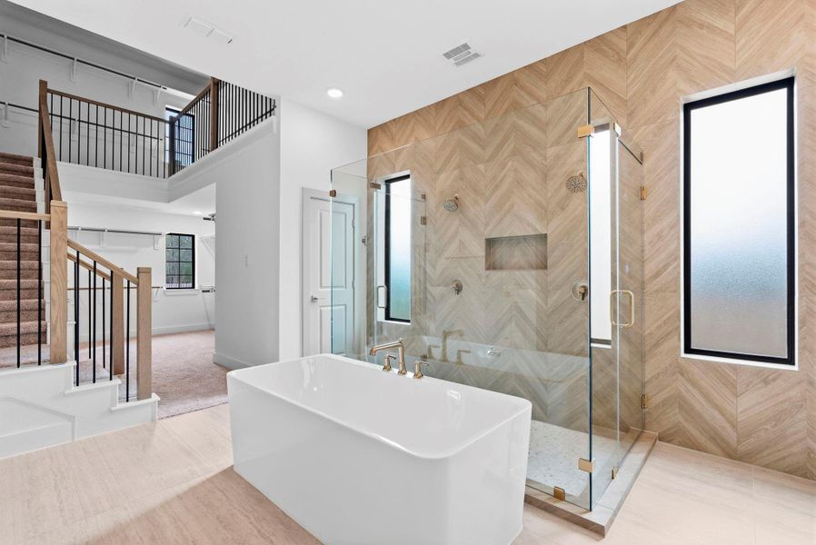 View of spa like primary bathroom upon entering, with views of the 2 story closet