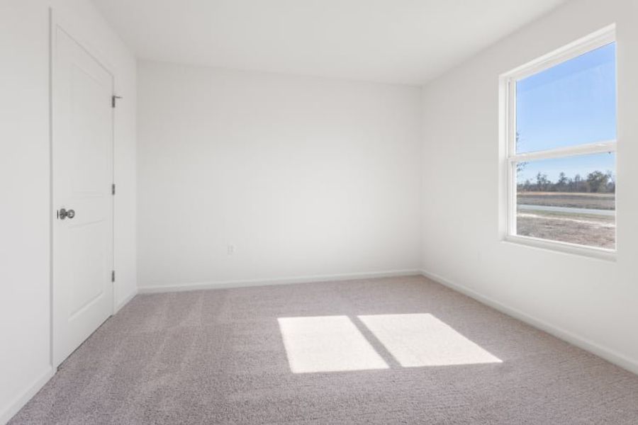 A room with a window and a rug in it.