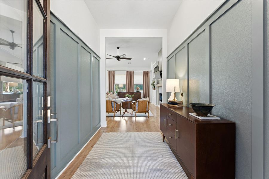 Hall with light wood-style flooring and a textured wall
