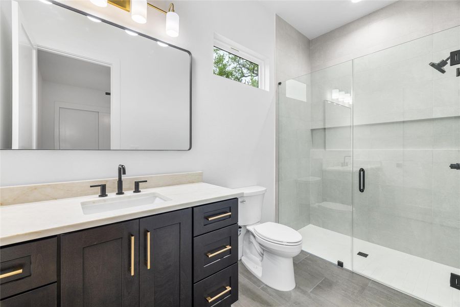 Full bath with vanity, a shower stall, and light wood finished floors. Full bath with vanity, a shower stall, and light wood finished floors.