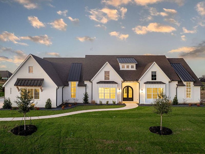 Modern farmhouse with a standing seam roof, a metal roof, and a lawn
