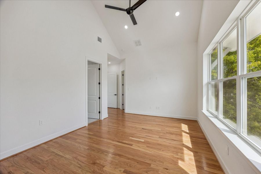 Elegant primary bedroom featuring a grand window that fills the space with natural light, highlighting the beautiful, high-quality flooring. This serene retreat combines spaciousness and refined finishes, creating a perfect sanctuary for rest and relaxation. Elegant primary bedroom featuring a grand window that fills the space with natural light, highlighting the beautiful, high-quality flooring. This serene retreat combines spaciousness and refined finishes, creating a perfect sanctuary for rest and relaxation.