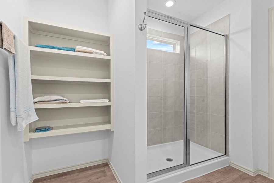 Gorgeous walk-in shower with seamless glass enclosure, transom window for natural light, gorgeous tile surroundings and built-in shelving nearby — practical and beautiful all in one. Gorgeous walk-in shower with seamless glass enclosure, transom window for natural light, gorgeous tile surroundings and built-in shelving nearby — practical and beautiful all in one.