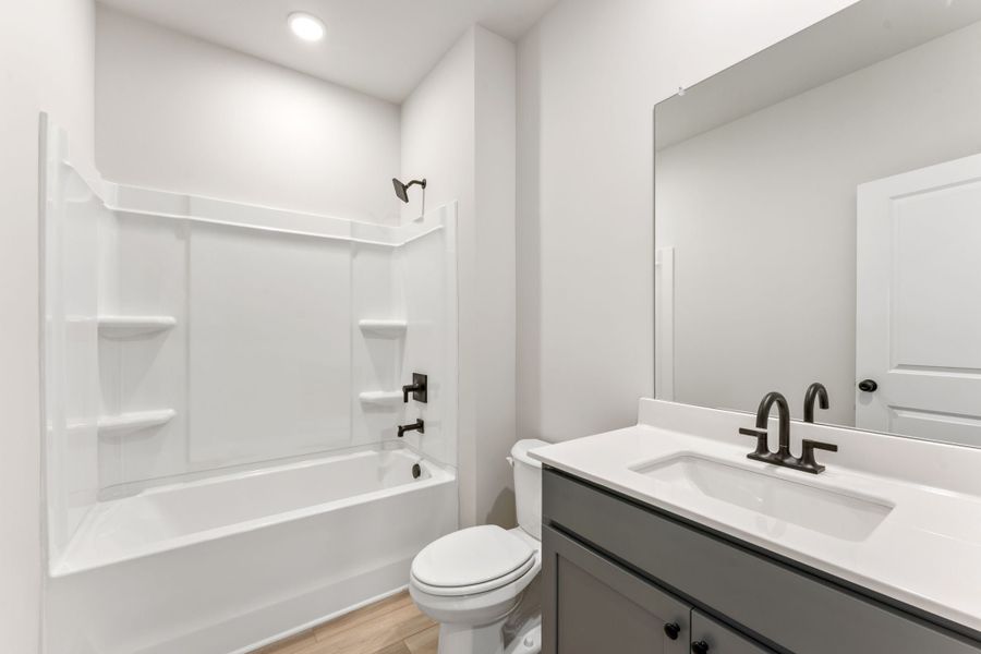 A bathroom with a tub sink and toilet.