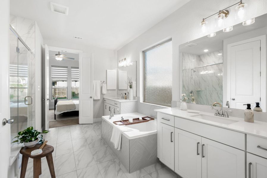 Indulge in a spa-like retreat with this well-appointed bathroom, showcasing a deep soaking tub and dual vanities.