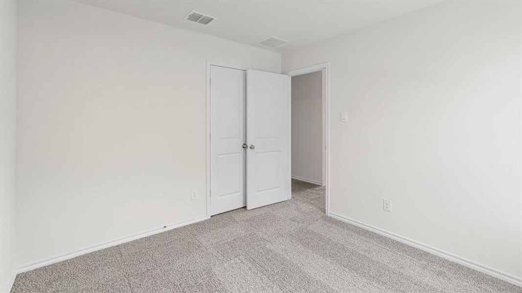 This room features light gray carpeting, white walls, and white trim