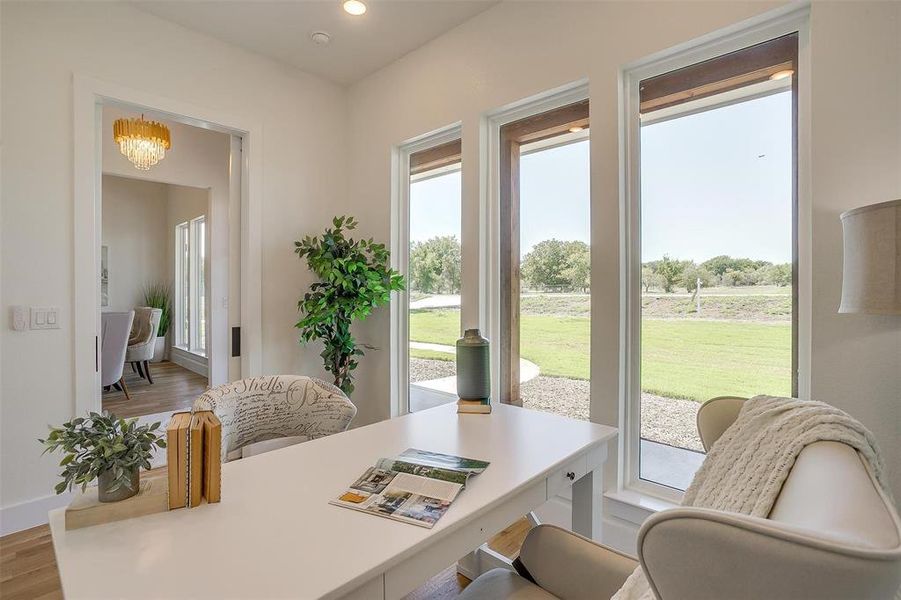 Office area featuring light hardwood / wood-style floors and a chandelier