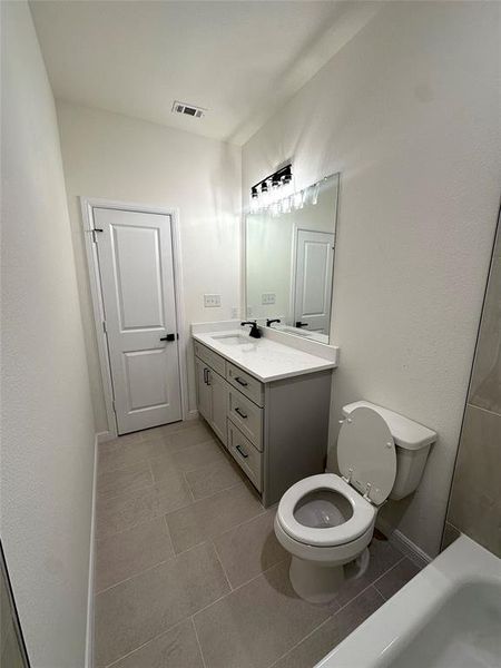 Bathroom with vanity, toilet, and tile patterned flooring