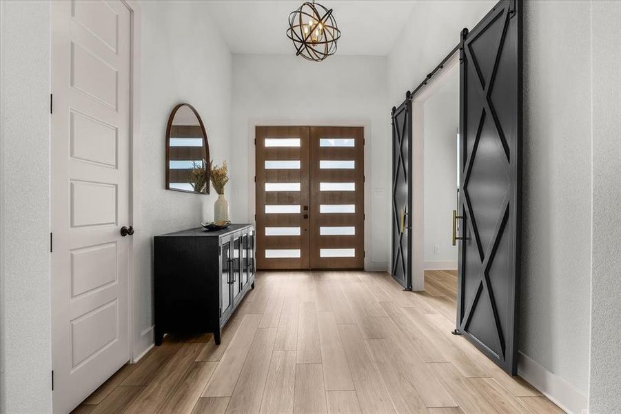 Stunning custom front doors with frosted privacy glass. Dual bold-black barn doors to right take you into large office. Coat closet to the left.