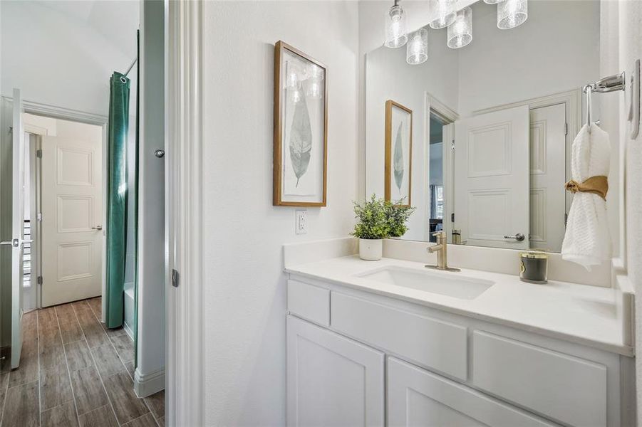 Bathroom vanity with a white countertop and undermount sink, complemented by a contemporary light fixture