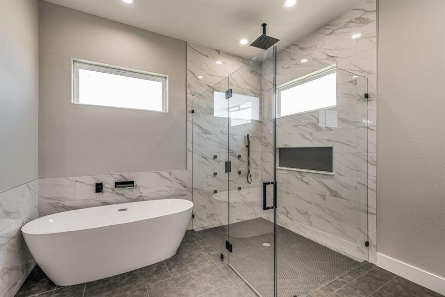 Bathroom with tile patterned floors, tile walls, and plus walk in shower