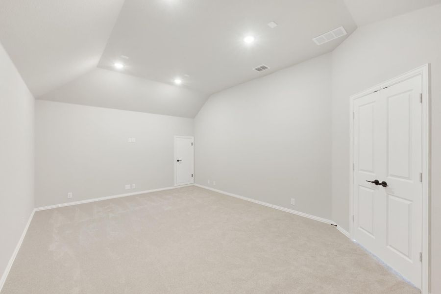 Empty bedroom with vaulted ceiling, recessed lighting, and beige carpet Empty bedroom with vaulted ceiling, recessed lighting, and beige carpet